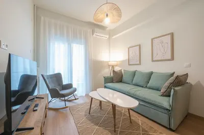a living room with a green couch and a tv at Zen sunny, Zografou in Athens