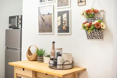 a table in a kitchen with flowers and a refrigerator at Zen sunny, Zografou in Athens