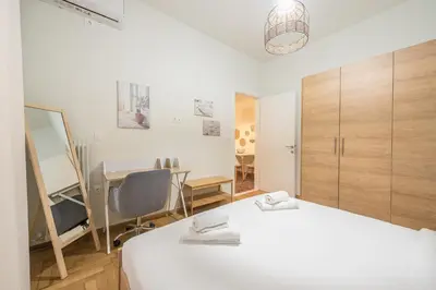 a bedroom with a white bed and a desk and a chair at Zen sunny, Zografou in Athens