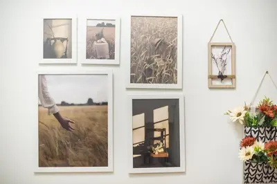 a wall of pictures on a white wall with a woman at Zen sunny, Zografou in Athens