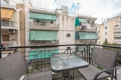 a balcony with two chairs and a building at Zen sunny, Zografou in Athens