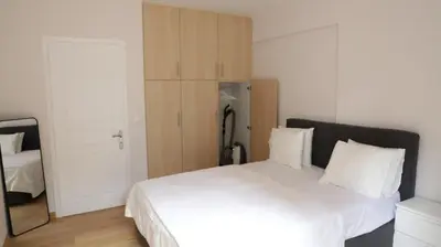 a bedroom with a large white bed and a refrigerator at Luxury 1 Bd Apt with Patio in Neo Psychiko in Athens