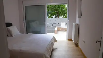 a bedroom with a white bed and a sliding glass door at Luxury 1 Bd Apt with Patio in Neo Psychiko in Athens