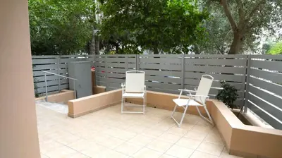 a patio with two chairs and a fence at Luxury 1 Bd Apt with Patio in Neo Psychiko in Athens