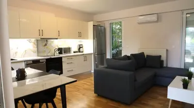 a kitchen and living room with a couch and a table at Luxury 1 Bd Apt with Patio in Neo Psychiko in Athens