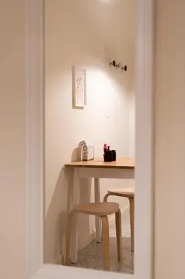 a table with two stools and a telephone in a room at Cozy 1BR Apt near Acropolis & Metro In Koukaki in Athens