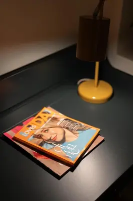 a magazine sitting on a desk next to a lamp at Cozy 1BR Apt near Acropolis & Metro In Koukaki in Athens