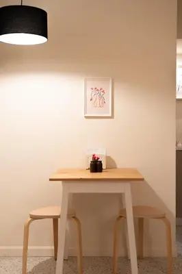 a table with two chairs and a picture on the wall at Cozy 1BR Apt near Acropolis & Metro In Koukaki in Athens
