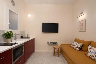 a living room with a couch and a tv at Cozy 1BR Apt near Acropolis & Metro In Koukaki in Athens
