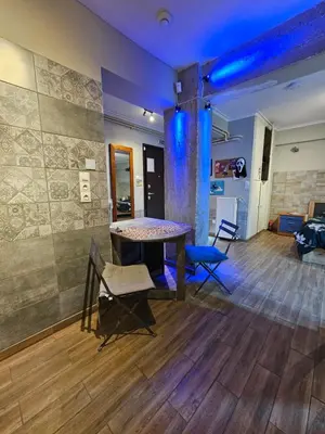 a room with a table and chairs in a room at Μοντέρνο Ημιυπόγειο στουντιο διαμέρισμα στην Αθήνα με αυλή in Athens