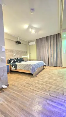a bedroom with a bed and a wooden floor at Μοντέρνο Ημιυπόγειο στουντιο διαμέρισμα στην Αθήνα με αυλή in Athens