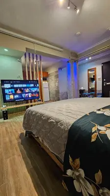 a bedroom with a large bed and a large television at Μοντέρνο Ημιυπόγειο στουντιο διαμέρισμα στην Αθήνα με αυλή in Athens