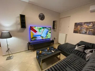 a living room with a couch and a flat screen tv at Athens Luxury & Smart Center House - Free Parking - 300 Mbps Fiber Wi-Fi in Athens
