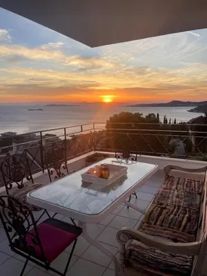 a table and chairs on a balcony with the sunset at Art Blue Residence Maisonette in Aghia Marina