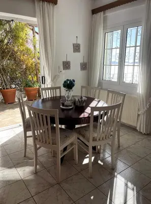 a dining room with a wooden table and chairs at Art Blue Residence Maisonette in Aghia Marina