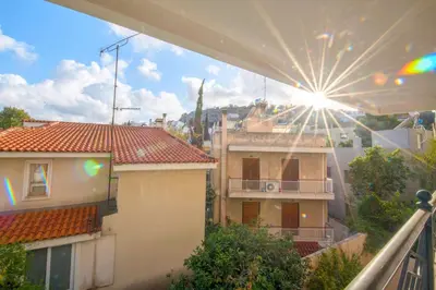 a view from a balcony of a building with the sun shining at Elegant Urban Retreat in Psychiko in Athens
