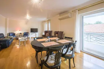 a dining room with a table and chairs and a living room at Elegant Urban Retreat in Psychiko in Athens