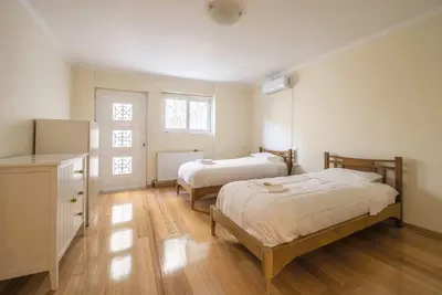 two beds in a room with wooden floors at Elegant Urban Retreat in Psychiko in Athens