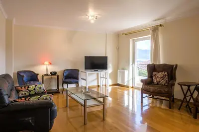 a living room with a couch and chairs and a tv at Elegant Urban Retreat in Psychiko in Athens