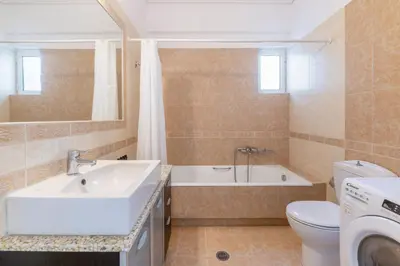 a bathroom with a sink and a tub and a toilet at The Glyfada Getaway 3BR with Balcony by UPSTREET in Athens
