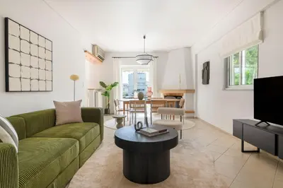 a living room with a green couch and a table at The Glyfada Getaway 3BR with Balcony by UPSTREET in Athens