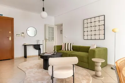 a living room with a green couch and a table at The Glyfada Getaway 3BR with Balcony by UPSTREET in Athens