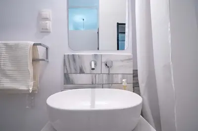 a white bathroom with a sink and a mirror at Artistic Bright Apartment - Attiki Metro by ΜΡS in Athens
