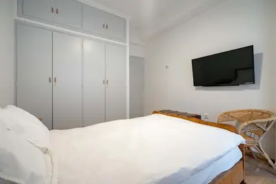 a bedroom with a bed and a flat screen tv at Artistic Bright Apartment - Attiki Metro by ΜΡS in Athens