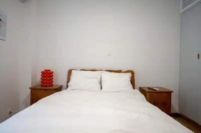 a bedroom with a white bed with two night stands at Artistic Bright Apartment - Attiki Metro by ΜΡS in Athens