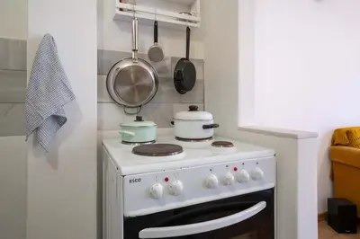 a small kitchen with a stove with pots and pans at Artistic Bright Apartment - Attiki Metro by ΜΡS in Athens