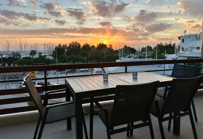 a table and chairs on a balcony with a view of a harbor at Elaia Luxury Selections - Aqua Marine in Athens