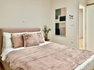 a white bedroom with a large bed with pink pillows at Elaia Luxury Selections - Aqua Marine in Athens