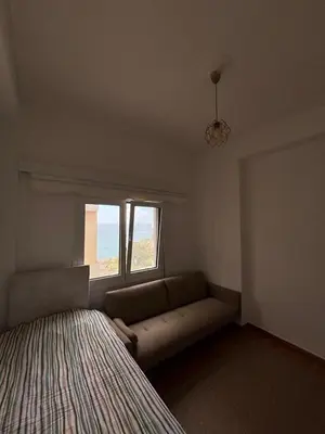 a small bedroom with a couch and a window at Apartment with sea view in Piraeus