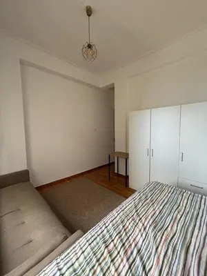 an empty bedroom with a bed and a table at Apartment with sea view in Piraeus