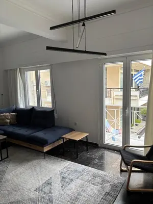 a living room with a blue couch and a table at Apartment with sea view in Piraeus