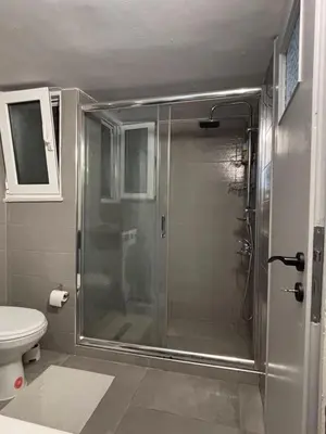 a glass shower in a bathroom with a toilet at Apartment with sea view in Piraeus
