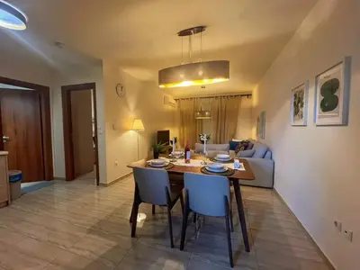 a kitchen and living room with a table and chairs at Alimos Skyline Balcony Home in Athens