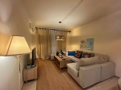 a living room with a couch and a tv at Alimos Skyline Balcony Home in Athens