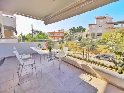 a balcony with a table and chairs and a large window at Alimos Skyline Balcony Home in Athens