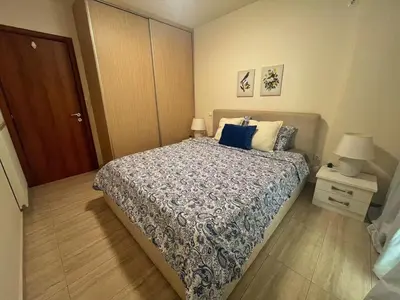 a bedroom with a bed with a blue and white comforter at Alimos Skyline Balcony Home in Athens