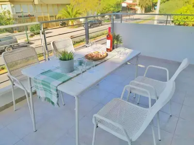 a white table and chairs with a pizza on a balcony at Alimos Skyline Balcony Home in Athens