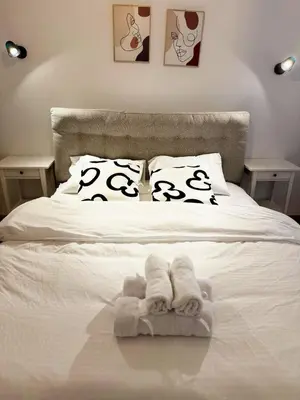 a white bed with towels and pillows on it at The Cozy Spot Athens in Athens