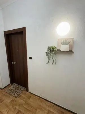 a hallway with a light and a plant on a wall at The Cozy Spot Athens in Athens