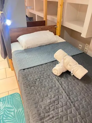 a bed with a stuffed animal laying on it at Sharing Apartment in Athens