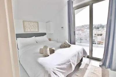 a bedroom with a white bed with towels on it at EL Attico, Αθήνα in Athens