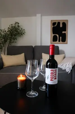 a bottle of wine and two wine glasses on a table at EL Attico, Αθήνα in Athens