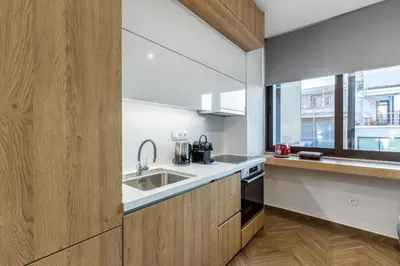 a kitchen with wooden cabinets and a sink and a window at Artemis Moonlight Suit in Athens