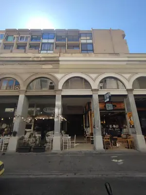 a building with tables and chairs in front of it at Artemis Moonlight Suit in Athens