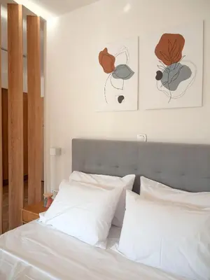 a bedroom with a bed with two paintings on the wall at Artemis Moonlight Suit in Athens
