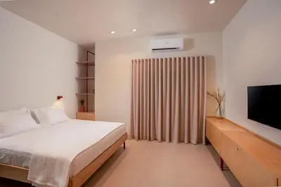 a bedroom with a bed and a flat screen tv at MelAngelo Villas A - Modern Studio near Port of Piraeus in Piraeus